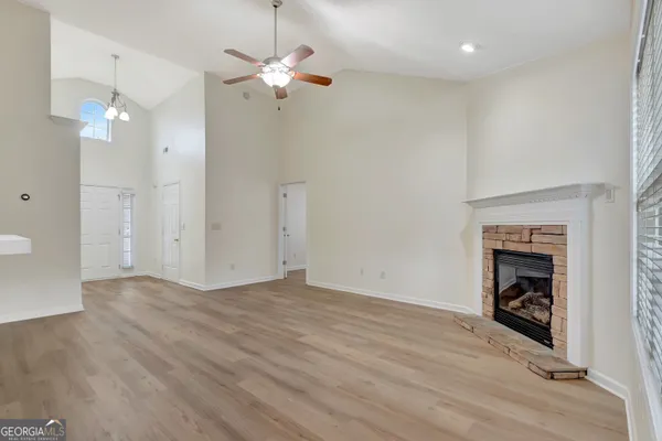 an empty room with a fireplace and fan