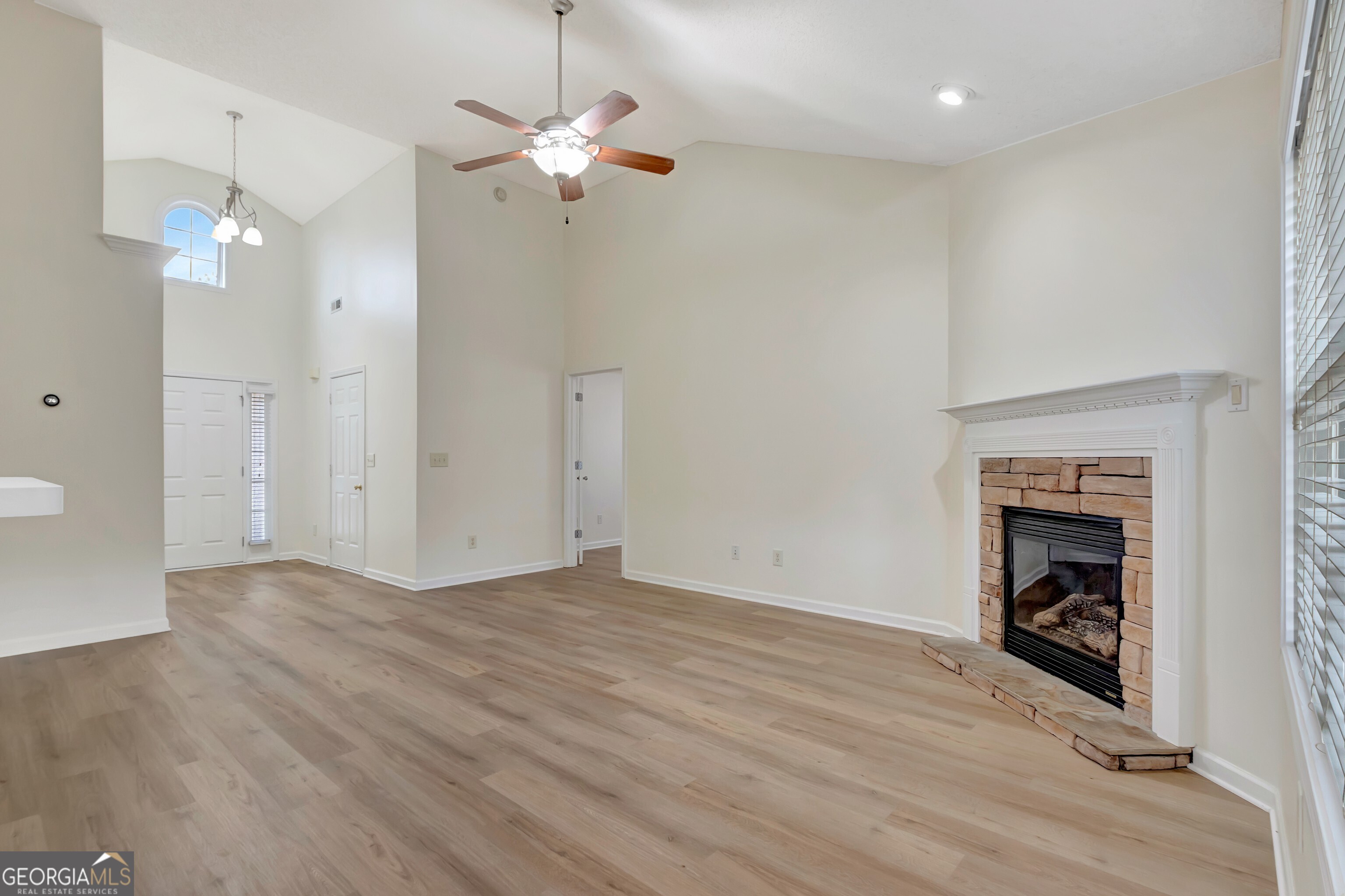 503 Hunterian Place Newnan, GA 30265 - Photo 13 of 28 an empty room with a fireplace and fan