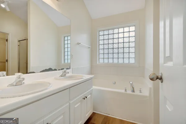a bathroom with a tub sink and mirror
