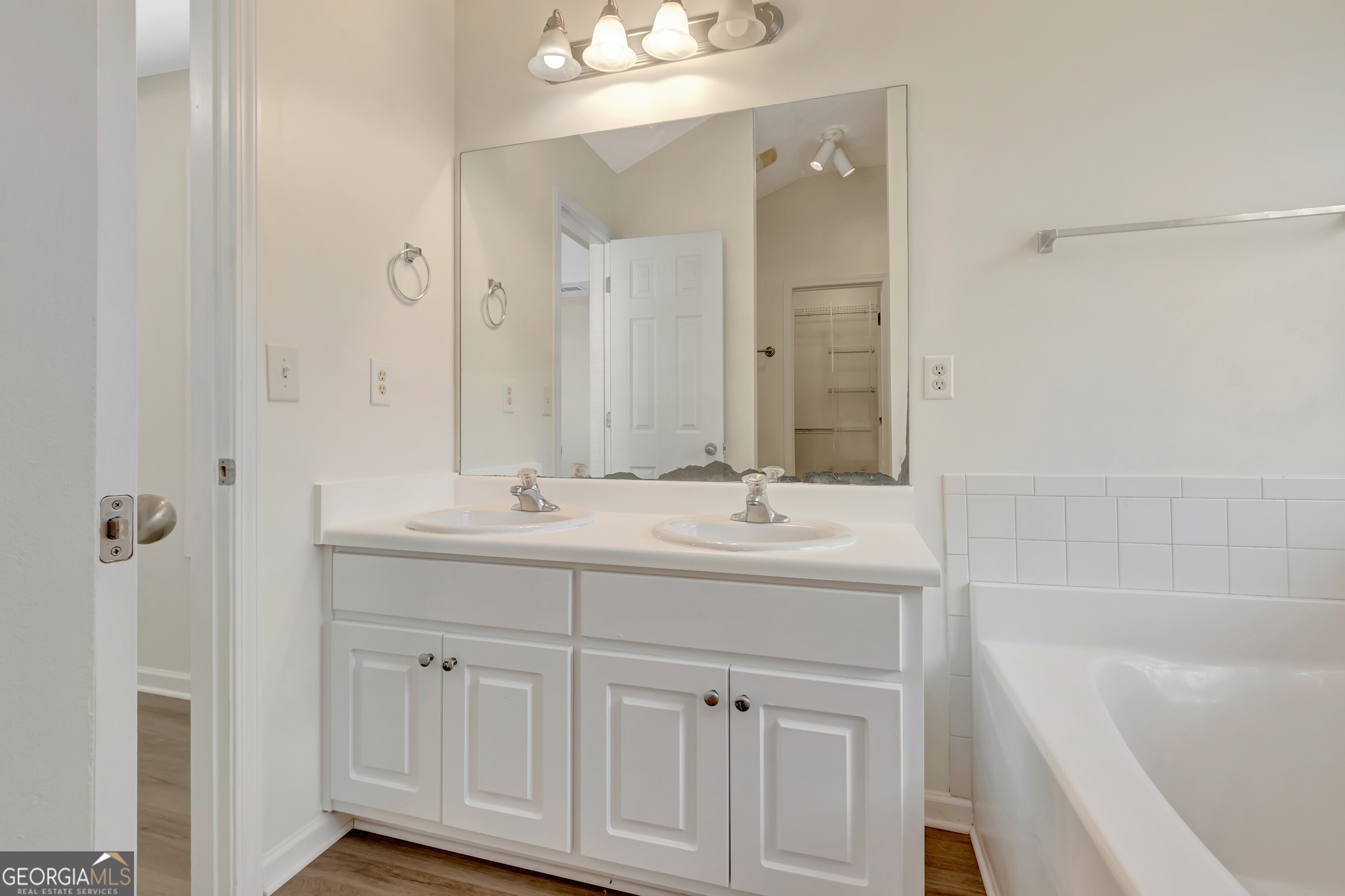 503 Hunterian Place Newnan, GA 30265 - Photo 22 of 28 a bathroom with a double vanity sink a mirror and a bathtub