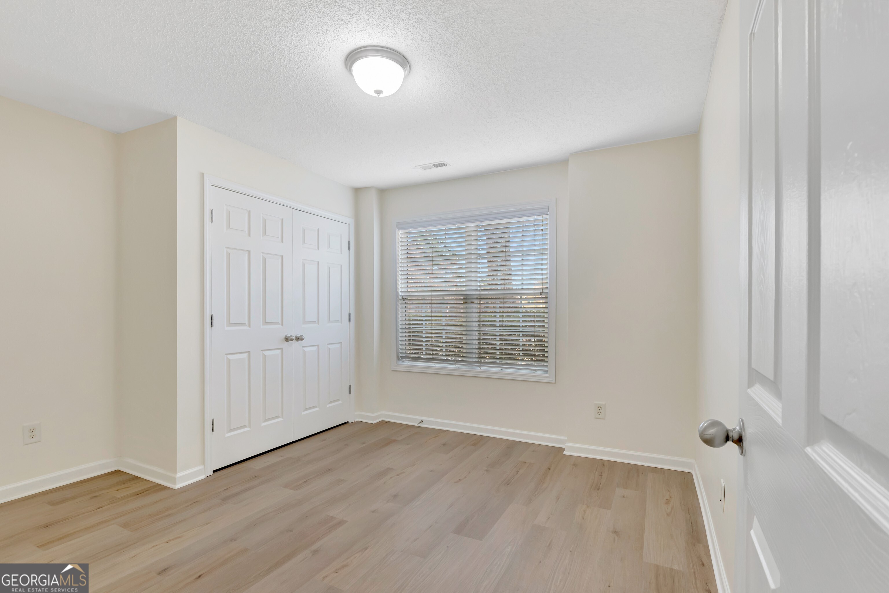 503 Hunterian Place Newnan, GA 30265 - Photo 8 of 28 an empty room with wooden floor and windows