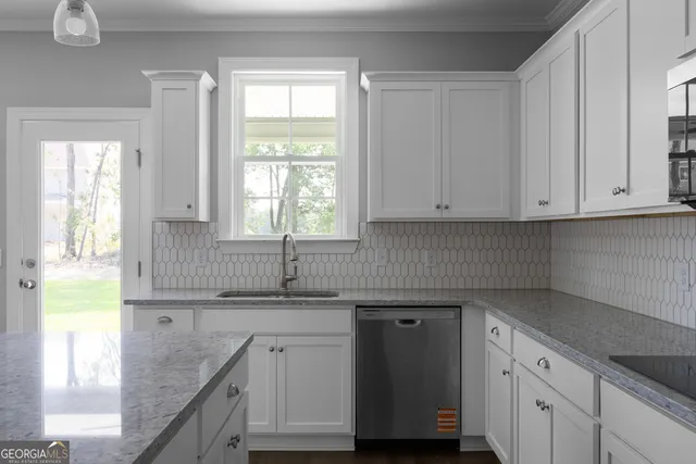 a kitchen with granite countertop a sink a window and cabinets