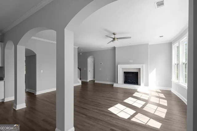 a view of empty room with wooden floor and fireplace