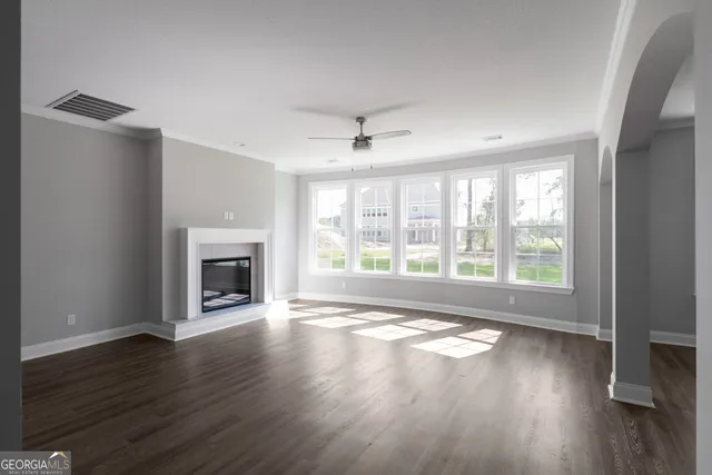a view of empty room with wooden floor and fireplace