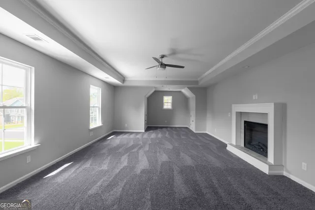 a view of an empty room with a fireplace and a window