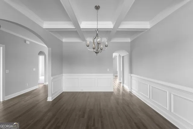 a view of a hallway with wooden floor and chandelier