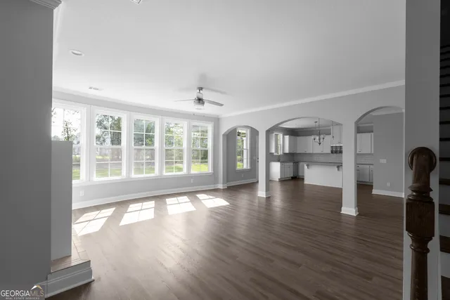 a view of empty room with wooden floor and floor to ceiling window