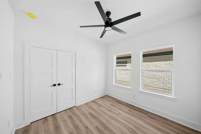 a view of empty room with wooden floor and window