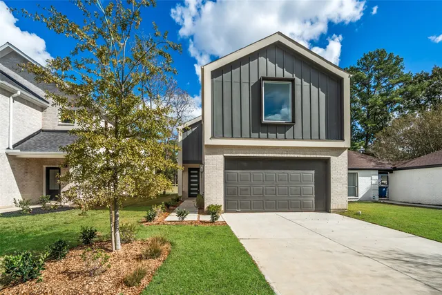a front view of a house with a garden and trees