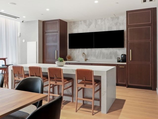 a kitchen with stainless steel appliances a kitchen island a stove a table and chairs