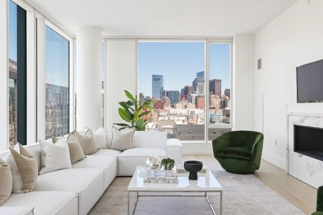 a living room with furniture a flat screen tv and a large window