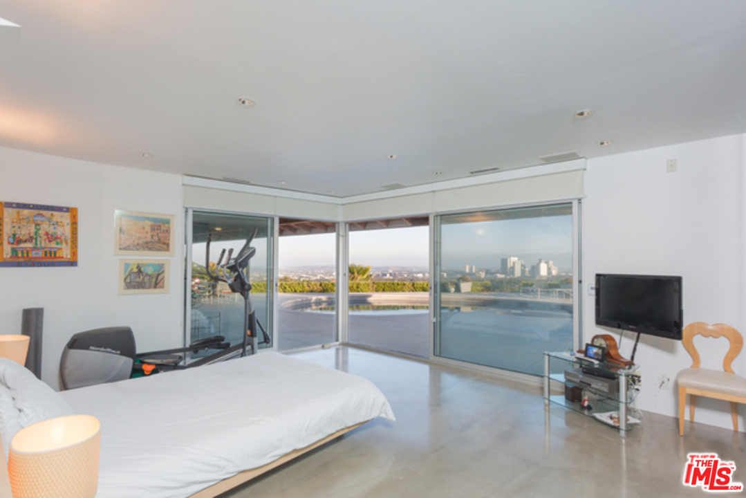 1230 Shadow Hill Way Beverly Hills, CA 90210 - Photo 13 of 22 a bedroom with furniture and a flat screen tv