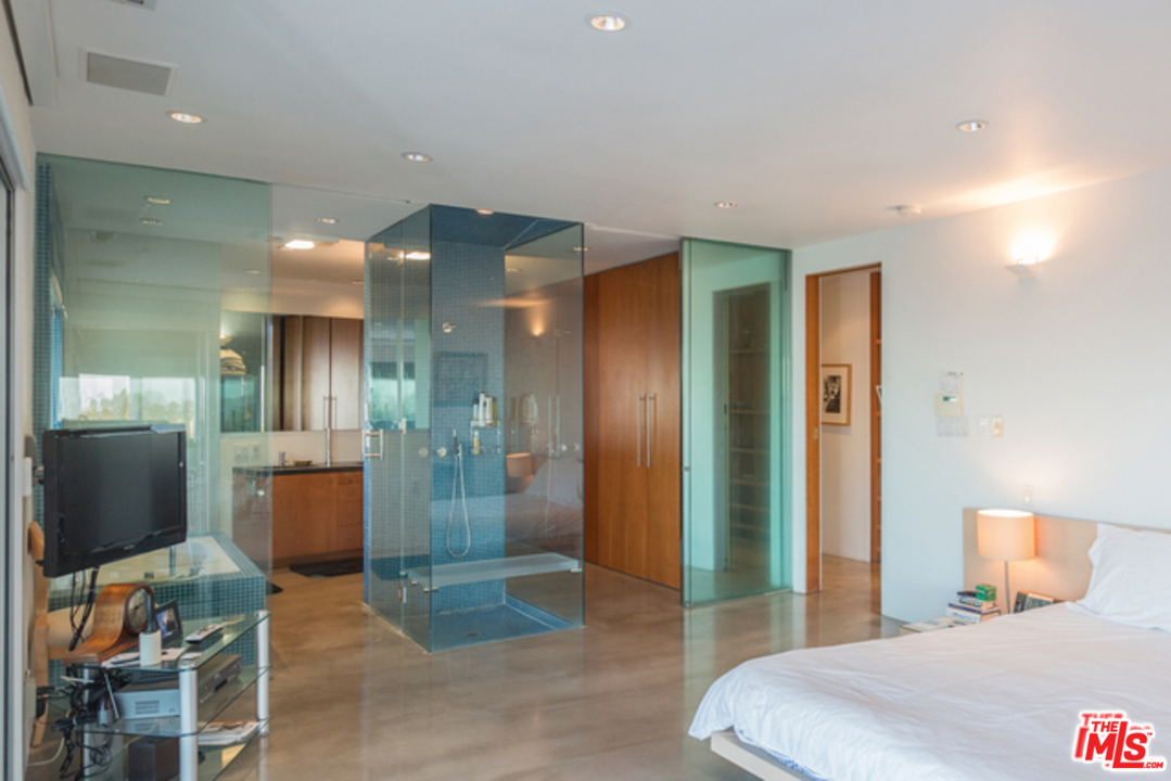 1230 Shadow Hill Way Beverly Hills, CA 90210 - Photo 19 of 22 a bedroom with a bed and glass door