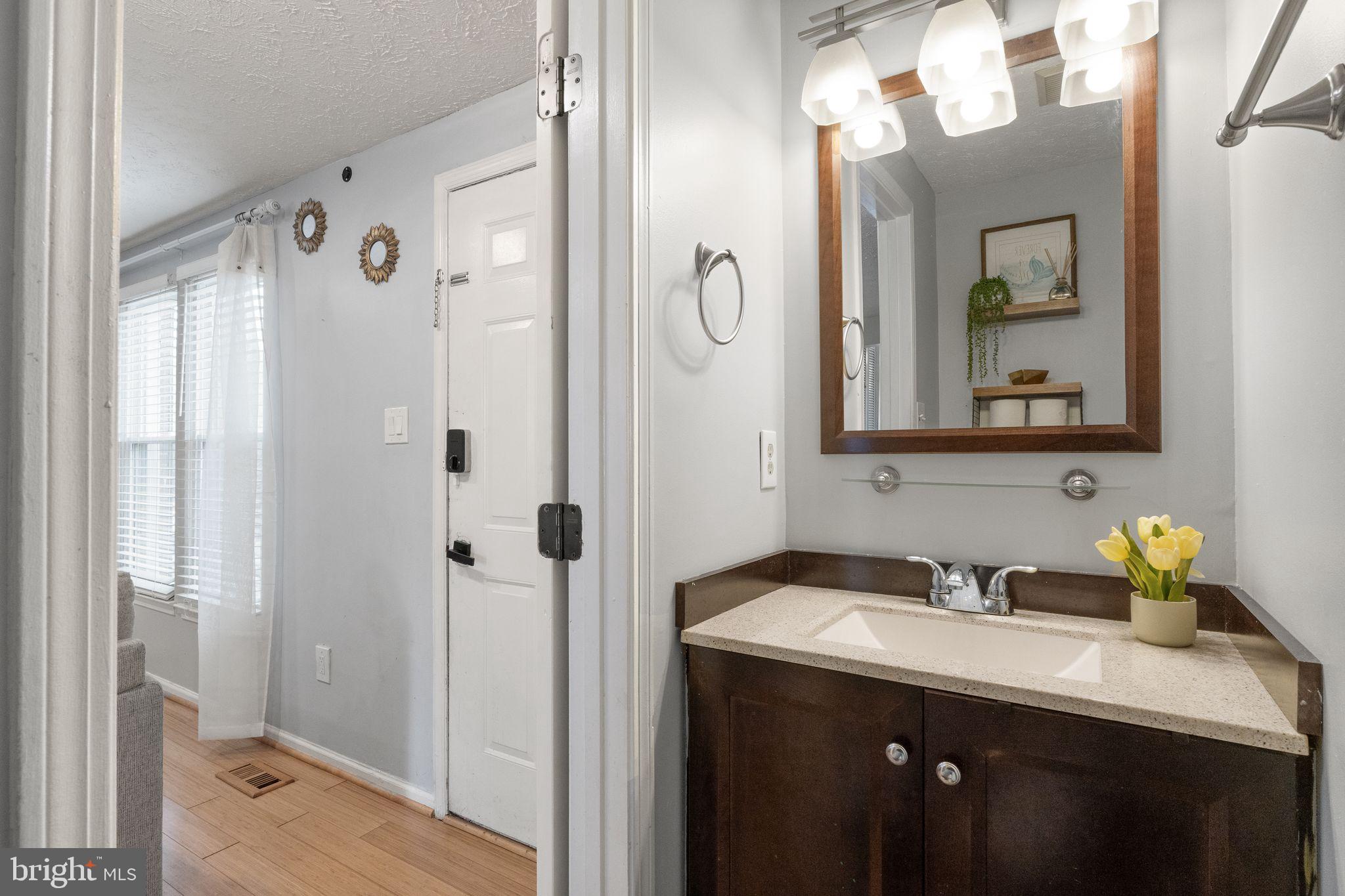 7457 Wounded Knee Road Lorton, VA 22079 - Photo 18 of 49 a bathroom with a sink and mirror with shower