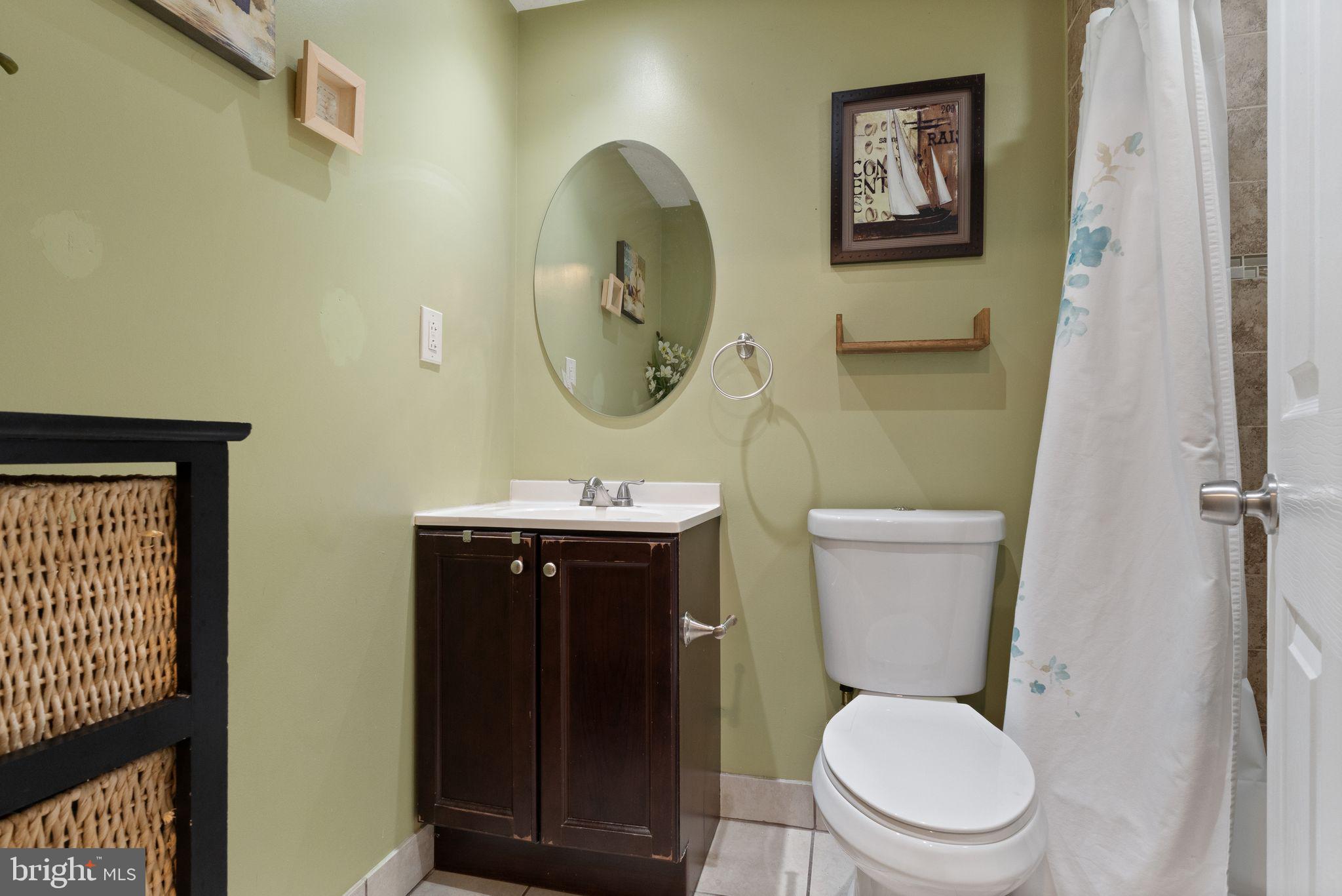 7457 Wounded Knee Road Lorton, VA 22079 - Photo 30 of 49 a bathroom with a toilet a sink and mirror