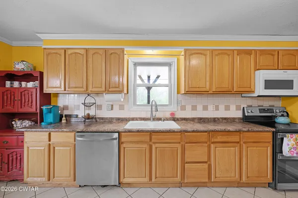 a kitchen with granite countertop white cabinets sink and stainless steel appliances