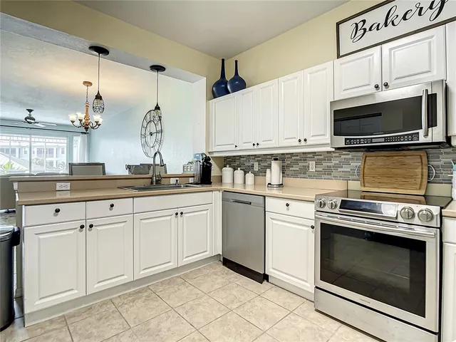 a kitchen with cabinets stainless steel appliances and a counter space