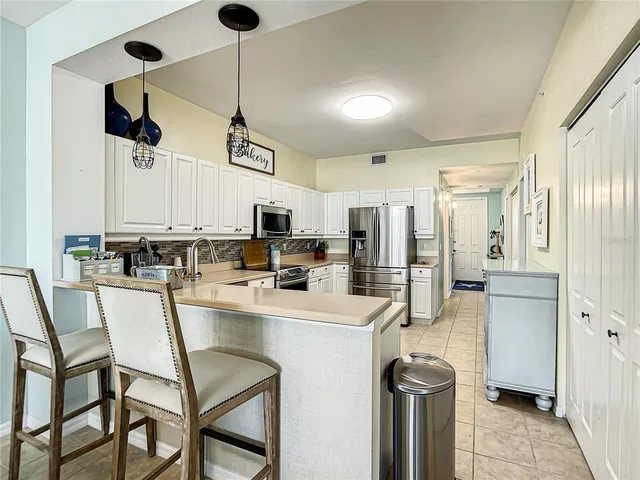 a kitchen with stainless steel appliances granite countertop a stove a refrigerator and a microwave