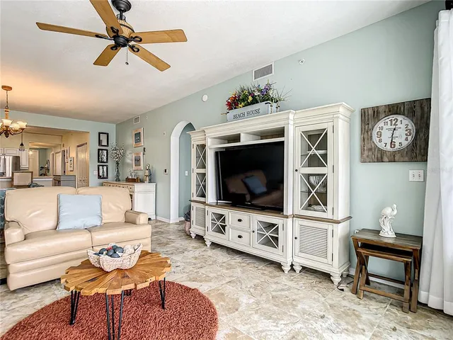 a living room with furniture a flat screen tv and a large window