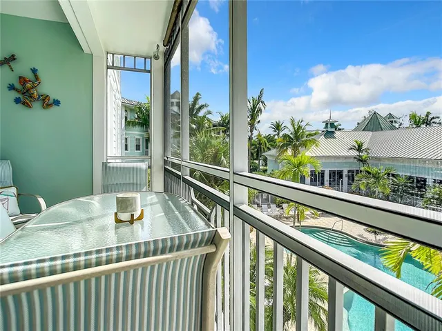 a large kitchen with granite countertop a stove a sink dishwasher a dining table and chairs with wooden floor