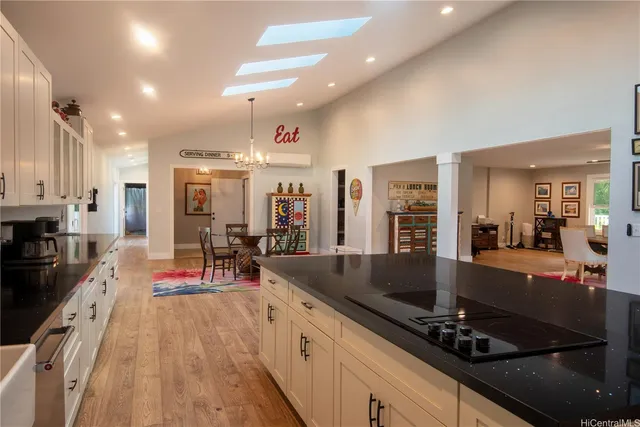 a large kitchen with lots of counter top space a sink and stainless steel appliances