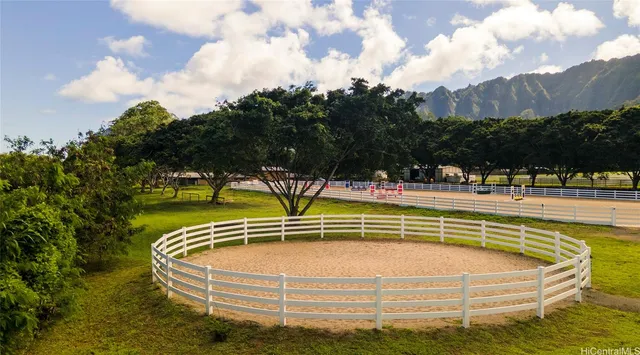 a view of swimming pool with outdoor seating and trees in the background