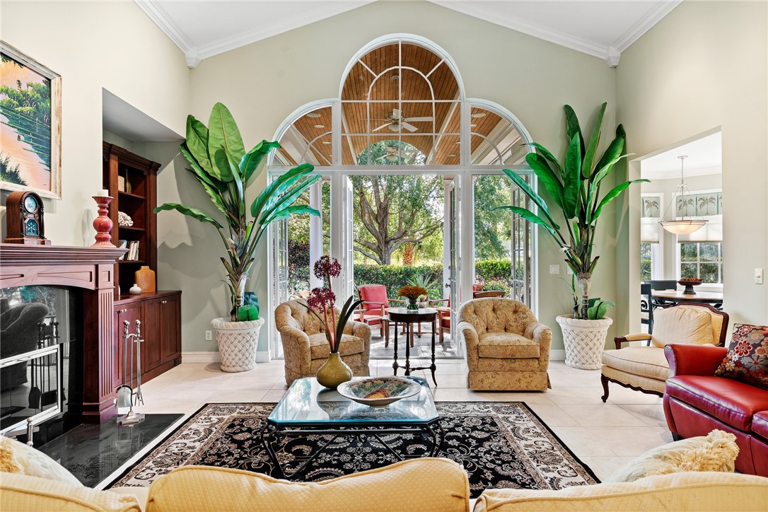 a living room with patio furniture and a potted plant
