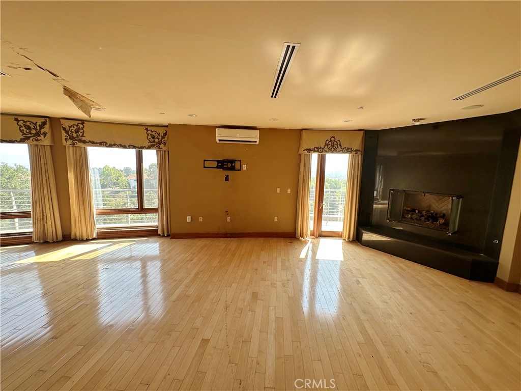 5077 Schumacher Road Calabasas, CA 91302 - Photo 17 of 58 a view of empty room with wooden floor and fireplace