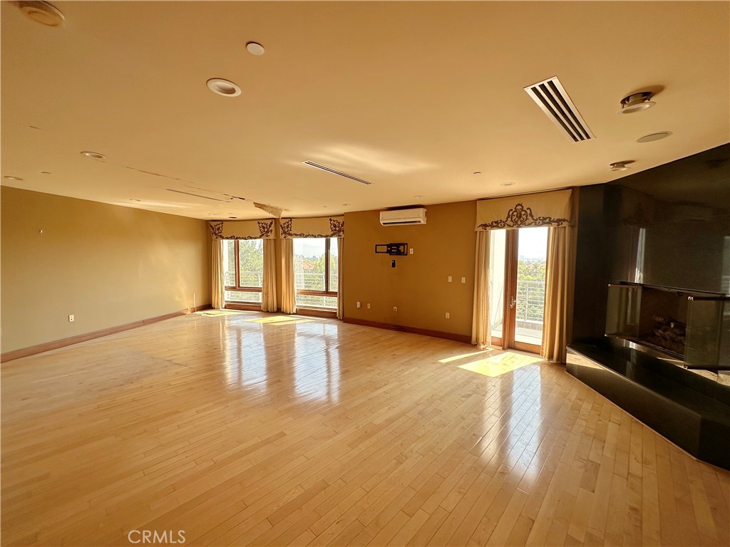 5077 Schumacher Road Calabasas, CA 91302 - Photo 18 of 58 a view of an empty room with window and wooden floor