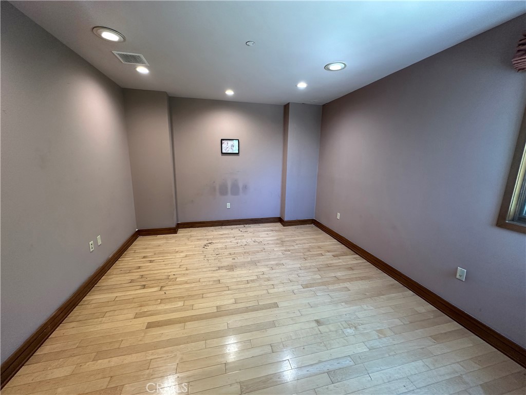 5077 Schumacher Road Calabasas, CA 91302 - Photo 26 of 58 an empty room with wooden floor and windows