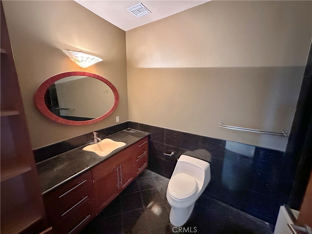 5077 Schumacher Road Calabasas, CA 91302 - Photo 31 of 58 a bathroom with a toilet a sink and a mirror