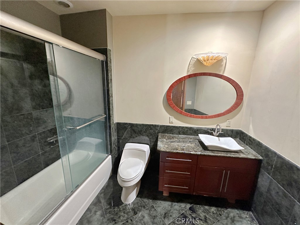 5077 Schumacher Road Calabasas, CA 91302 - Photo 34 of 58 a bathroom with a granite countertop toilet sink mirror vanity and bathtub