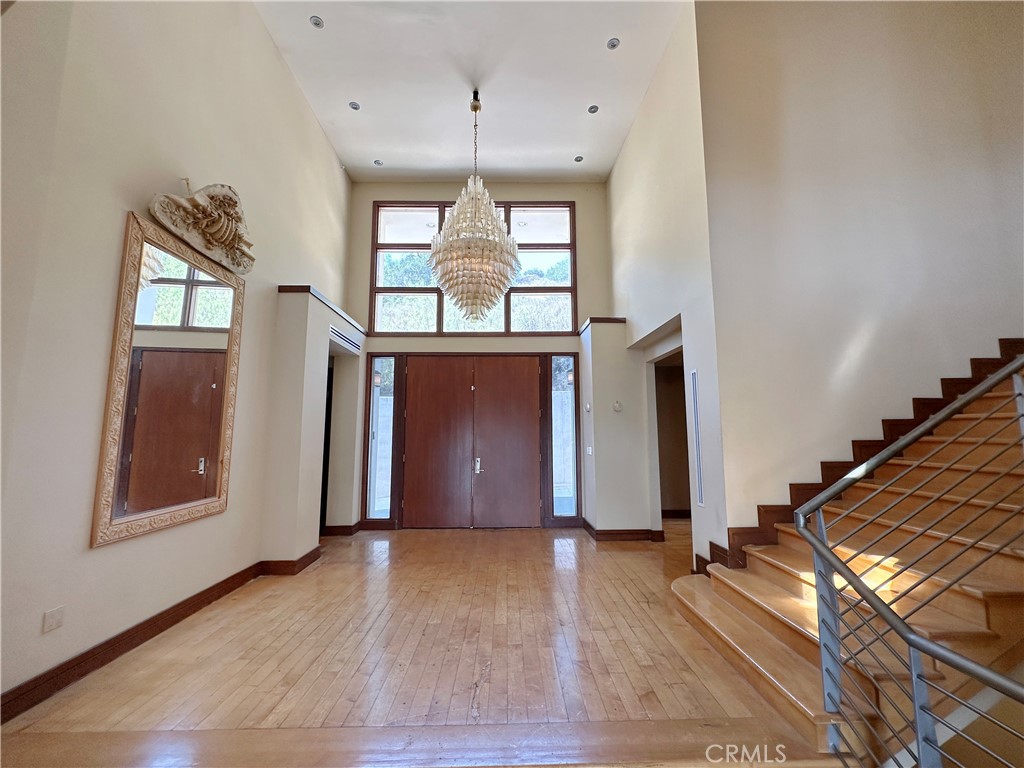 5077 Schumacher Road Calabasas, CA 91302 - Photo 6 of 58 an empty room with wooden floor and windows