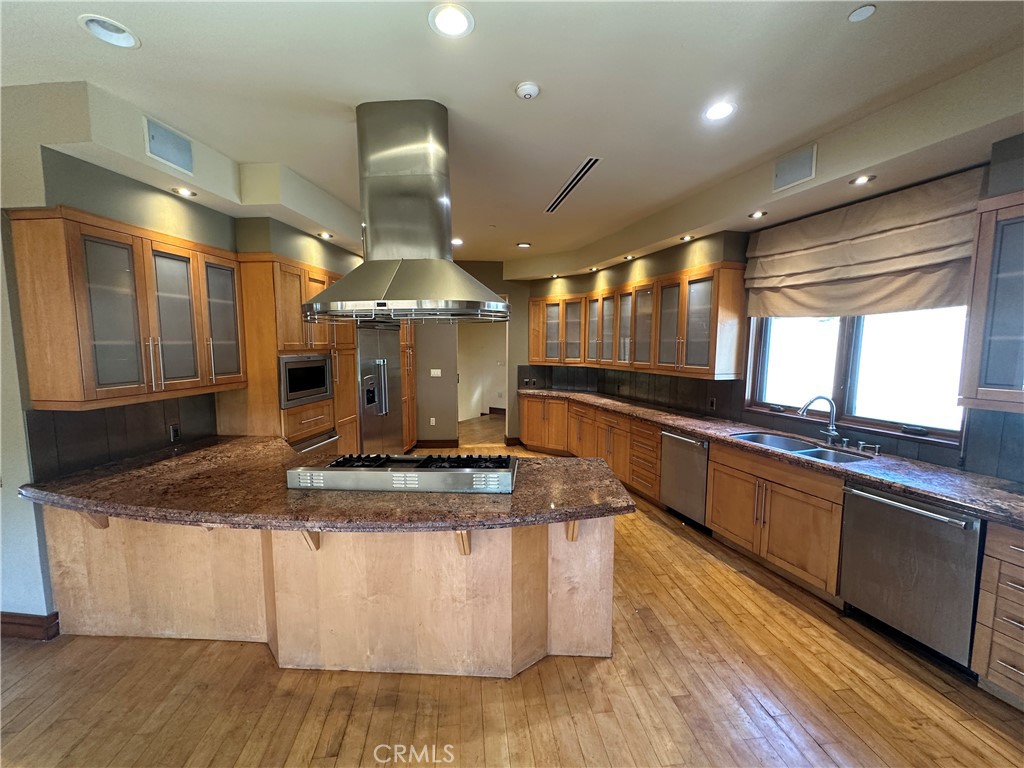 5077 Schumacher Road Calabasas, CA 91302 - Photo 9 of 58 a large kitchen with stainless steel appliances granite countertop a large stove a sink and a granite counter tops with a large window