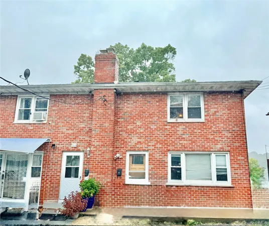 front view of a brick house with a yard