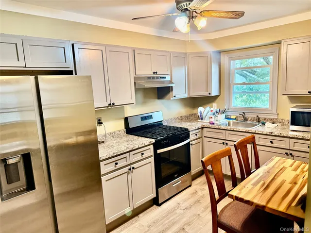 a kitchen with stainless steel appliances granite countertop a stove refrigerator sink and cabinets