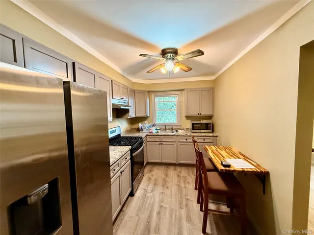 a kitchen with a refrigerator a sink and chairs