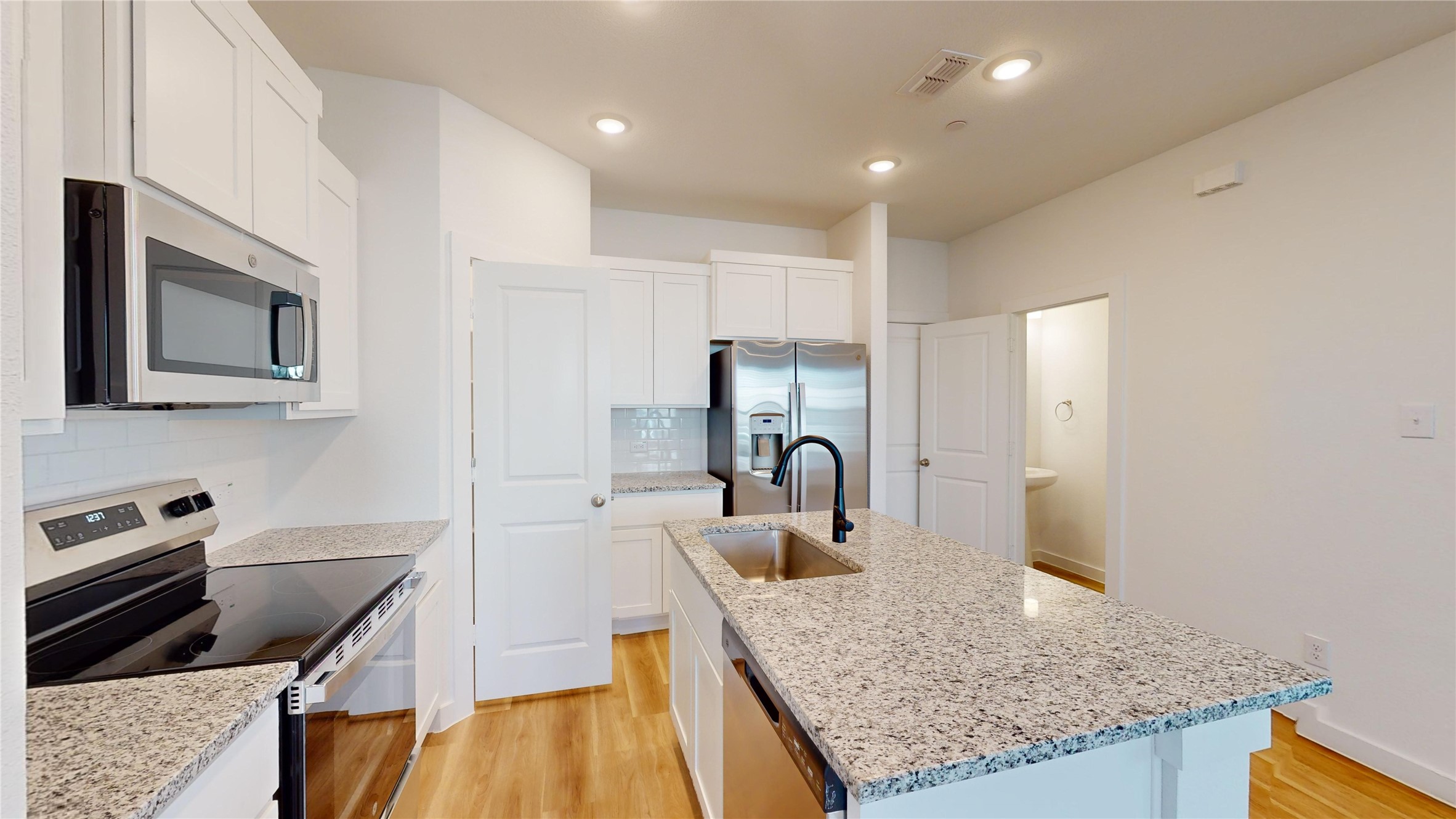4125 Floyd Alley Grand Prairie, TX 75052 - Photo 11 of 45 a kitchen with kitchen island granite countertop a stove and a sink