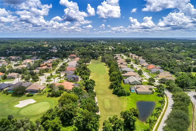 an aerial view of residential houses with outdoor space and trees