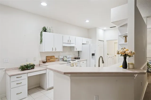 a kitchen with white cabinets and sink