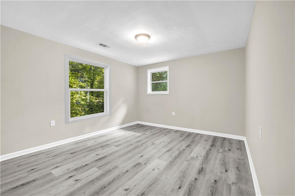 305 South 18th Street Griffin, GA 30224 - Photo 11 of 36 an empty room with wooden floor and windows