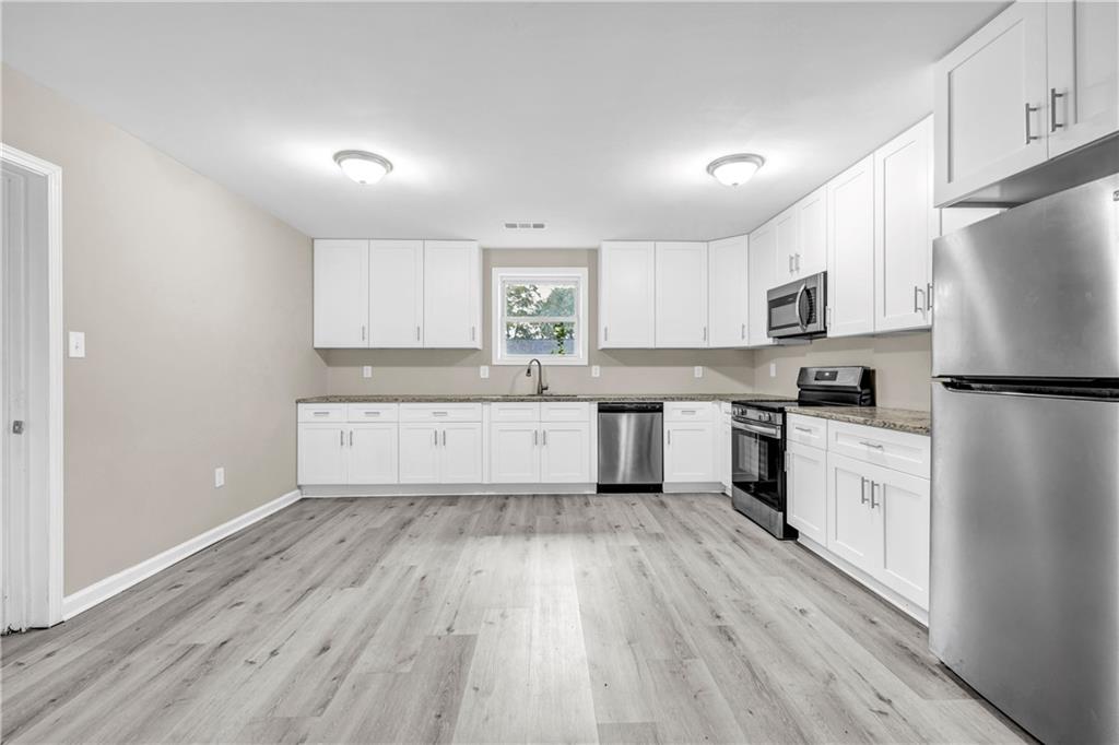 305 South 18th Street Griffin, GA 30224 - Photo 22 of 36 a kitchen with white cabinets and white appliances