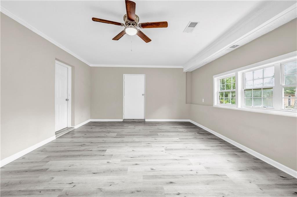 305 South 18th Street Griffin, GA 30224 - Photo 25 of 36 an empty room with wooden floor ceiling fan and windows