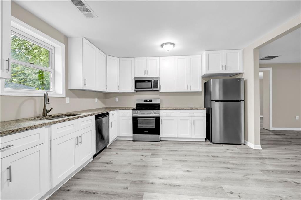 305 South 18th Street Griffin, GA 30224 - Photo 3 of 36 a kitchen with granite countertop a refrigerator and a sink