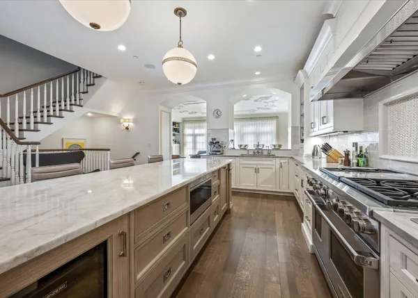 a large kitchen with stainless steel appliances granite countertop a lot of counter space and a sink