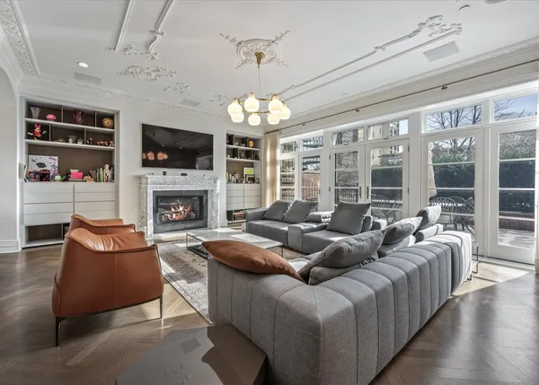 a living room with furniture a chandelier and a rug