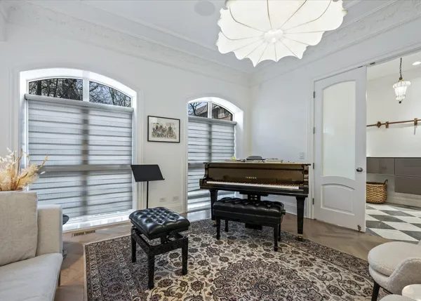 a living room with furniture a piano and a rug