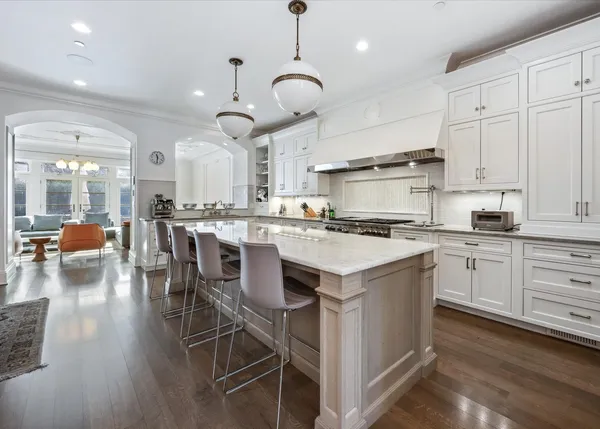 a kitchen with stainless steel appliances kitchen island granite countertop a table chairs and a cabinets