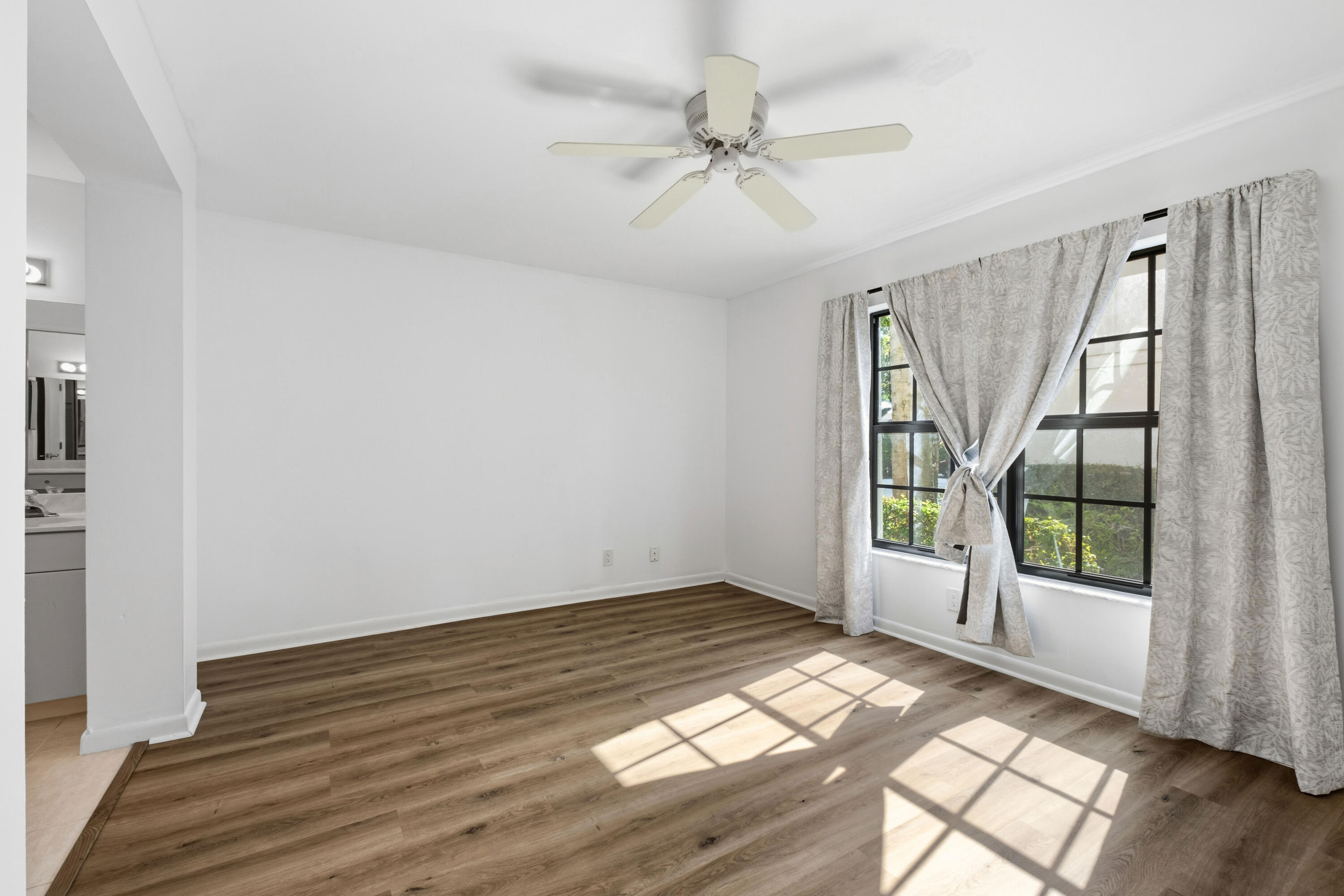3233 Perimeter Drive, Unit 2511 Greenacres, FL 33467 - Photo 12 of 39 an empty room with wooden floor fan and windows