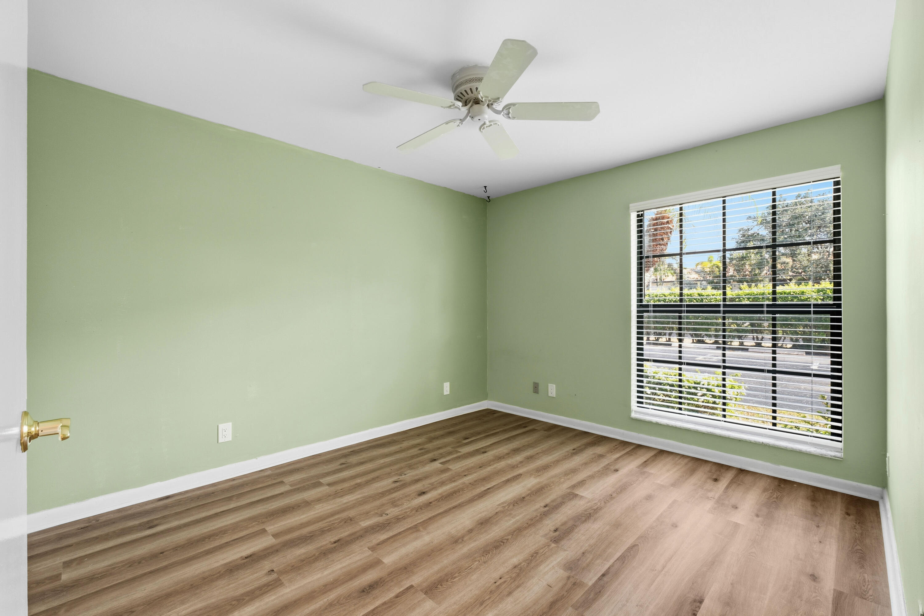 3233 Perimeter Drive, Unit 2511 Greenacres, FL 33467 - Photo 15 of 39 an empty room with wooden floor and windows